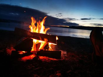 Bonfire on wooden structure against sky at night