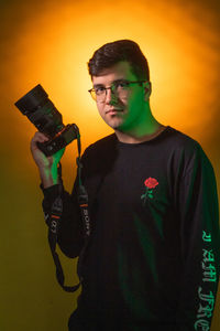 Portrait of young man standing against wall