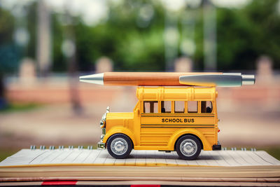 Close-up of book pen and toy bus