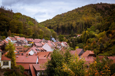 High angle view of trees by townscape against sky