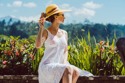 Woman wearing hat against plants