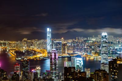 Illuminated modern buildings against sky at night