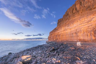 Rock formations by sea against sky