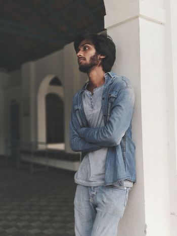 Young man standing against wall