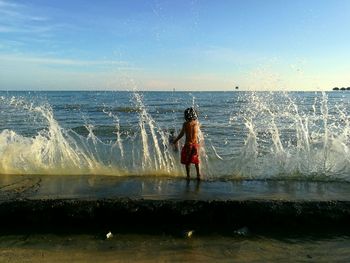 Rear view of woman standing in water