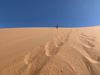 Scenic view of desert against clear blue sky