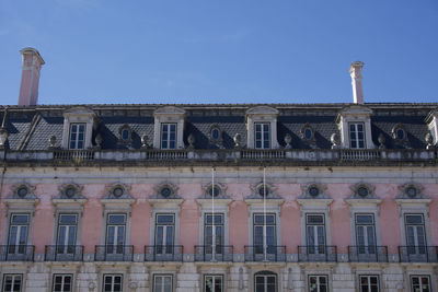 Pink building at rossio station in lisbon, portugal under clear blue sky