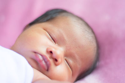 Close-up of baby with pink eyes