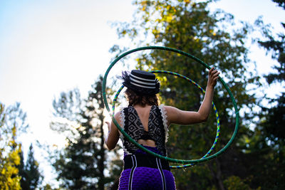 Midsection of woman standing by tree against plants