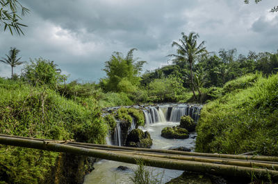 Scenic view of waterfall against sky