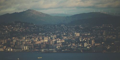 Aerial view of city and mountains against sky