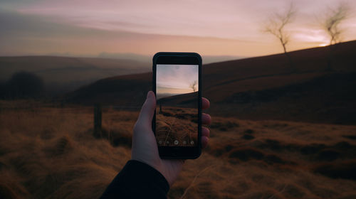 Cropped hand holding mobile phone