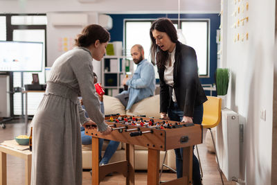 Business colleagues playing foosball at office