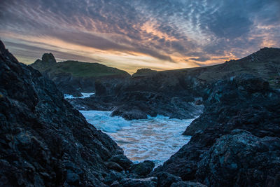 Scenic view of mountains against sky during sunset at kynance cove