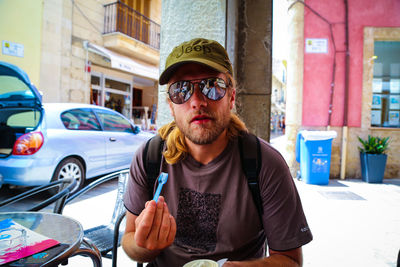 Portrait of young man wearing sunglasses eating ice cream