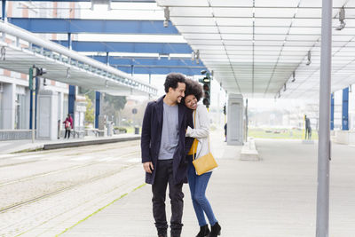 Man and woman walking at railroad station