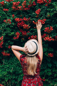 Midsection of woman with red flowers in park