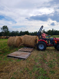 Hay bales on field against sky