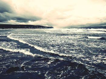 Scenic view of sea against cloudy sky