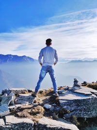 A man enjoying the view from the top of chadrashila peak, uttarakhand