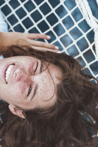 Close-up portrait of smiling young woman with freckles