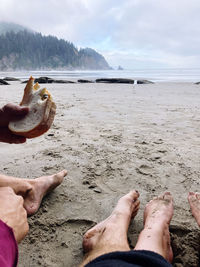 Low section of people relaxing on beach