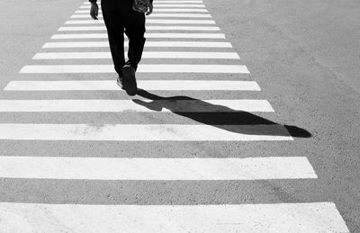 Low section of person walking on zebra crossing