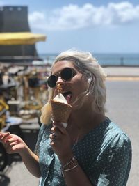 Midsection of woman eating ice cream outdoors