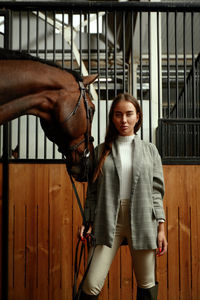 Portrait of smiling woman standing in stable