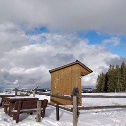 Built structure on snow field against sky