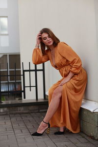 Young woman standing by wall