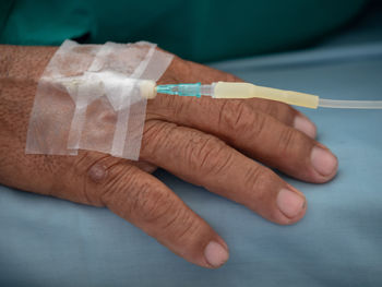 Close-up of man with iv drip at hospital