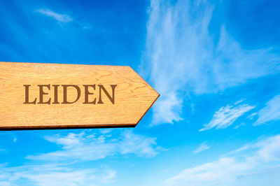 Low angle view of information sign against blue sky