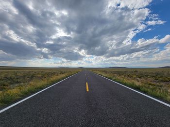 Road passing through land against sky