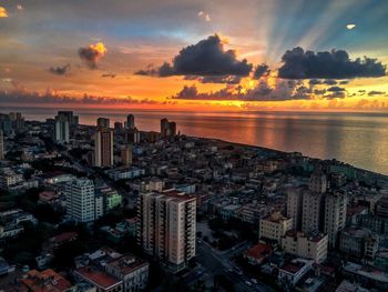 Aerial view of city at waterfront during sunset