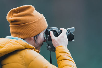 Rear view of man photographing through camera
