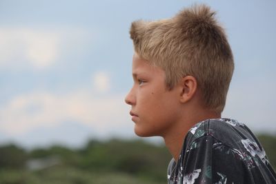 Close-up of boy against sky