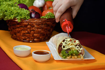 Cropped hand of man preparing food on table