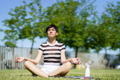 Portrait of young woman sitting on field