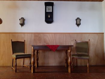 Empty chairs and table against wall at home