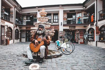 Statue on street against building in city
