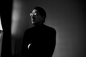 PORTRAIT OF MAN STANDING AGAINST WALL