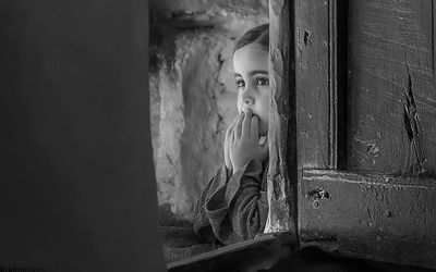 Close-up of young woman looking through window