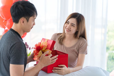 Young couple holding hands in box