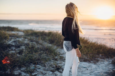 Rear view of young woman walking on beach