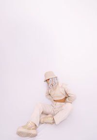 Full length of woman sitting against white background