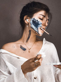 Close-up of woman with face paint against wall