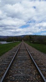 Railroad track against cloudy sky