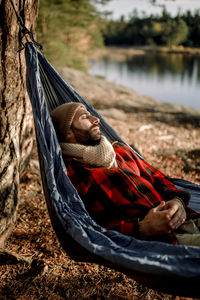 Man relaxing while lying down in hammock