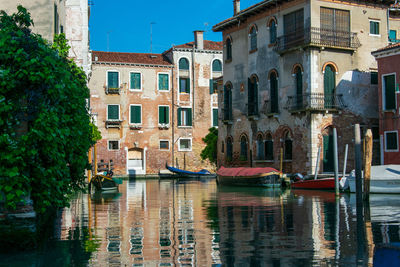 Canal by buildings in city